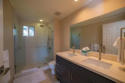 a bathroom with two sinks and a shower and a toilet at Del Mar 2J - 3bdr- 2bth Ocean view in Jacó
