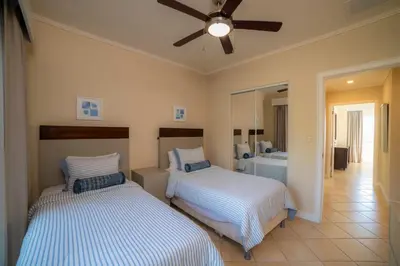 a bedroom with two beds and a ceiling fan at Del Mar 2J - 3bdr- 2bth Ocean view in Jacó