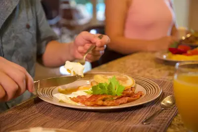 a person eating a breakfast plate of food on a table at Del Mar 2J - 3bdr- 2bth Ocean view in Jacó