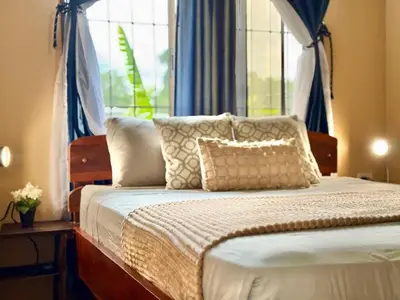 a bedroom with a bed with pillows and a window at 2 Tiny Houses Private Pool Volcano View 6 people in Fortuna