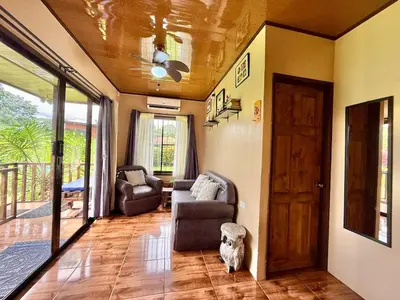 a living room with a couch and a door at 2 Tiny Houses Private Pool Volcano View 6 people in Fortuna
