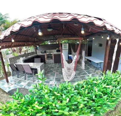a patio with a table and chairs under a pavilion at 2 Tiny Houses Private Pool Volcano View 6 people in Fortuna