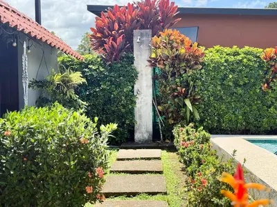 a garden with flowers and a swimming pool at 2 Tiny Houses Private Pool Volcano View 6 people in Fortuna