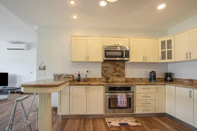 a kitchen with white cabinets and a microwave at Jaco Bay 4303 in Jacó