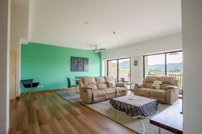 a living room with two couches and a blue wall at Jaco Bay 4303 in Jacó