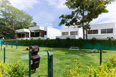 a white house with a tennis court in a yard at Selva Coral 0701 in Jacó