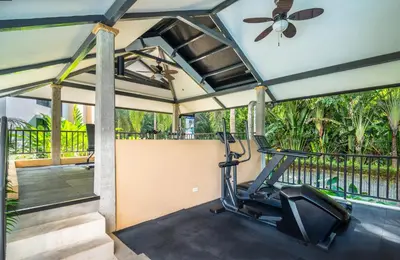a gym with a treadmill and a ceiling fan at Torres del Mar 1202 in Jacó