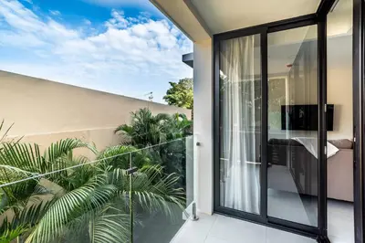 an open balcony with glass doors and plants at Torres del Mar 1202 in Jacó