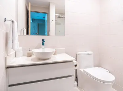 a white bathroom with a sink and a toilet at Torres del Mar 1202 in Jacó
