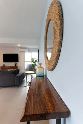 a living room with a wooden table and a mirror at Viva Jaco Viva Jaco (10-03B) in Jacó
