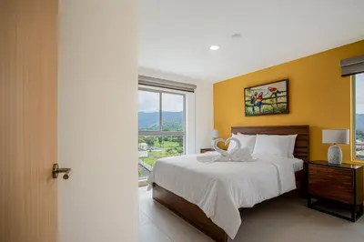 a bedroom with a bed and a large window at Viva Jaco Viva Jaco (10-03B) in Jacó