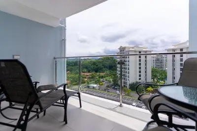 a balcony with chairs and a view of a city at Viva Jaco Viva Jaco (10-03B) in Jacó