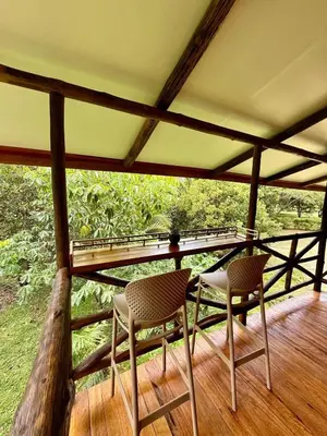 two chairs and a table on a porch at Casa Oropéndola Refugio natural en Guanacaste in Bagaces
