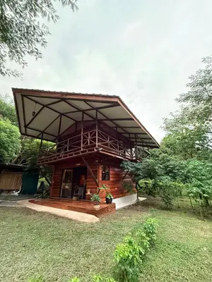 a wooden house with a large roof at Casa Oropéndola Refugio natural en Guanacaste in Bagaces