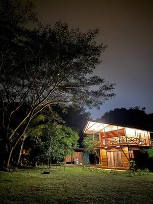 a building with a tree in front of it at night at Casa Oropéndola Refugio natural en Guanacaste in Bagaces