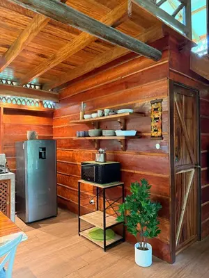 a kitchen with wooden walls and a stove and a refrigerator at Casa Oropéndola Refugio natural en Guanacaste in Bagaces
