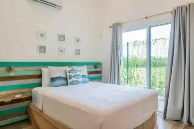 a bedroom with a large bed and a large window at Casa Ocean with Studio -Triskele Retreat in Esterillos