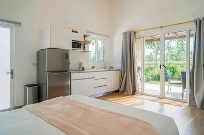 a kitchen with a stainless steel refrigerator and a sliding glass door at Casa Ocean with Studio -Triskele Retreat in Esterillos