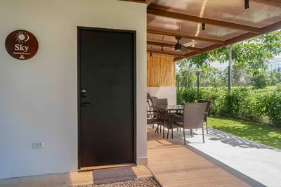 a black door on a patio with a table at Casa Ocean with Studio -Triskele Retreat in Esterillos