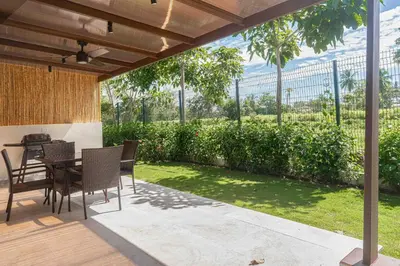a patio with a table and chairs and a garden at Casa Ocean with Studio -Triskele Retreat in Esterillos