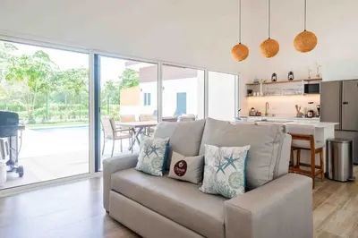 a living room with a couch and a kitchen at Casa Ocean with Studio -Triskele Retreat in Esterillos