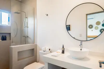 a white bathroom with a sink and a mirror at Entire Property - Triskele Retreat in Esterillos