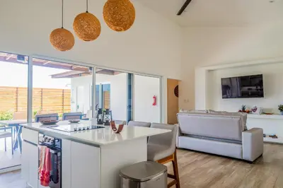 a kitchen and living room with a table and chairs at Entire Property - Triskele Retreat in Esterillos