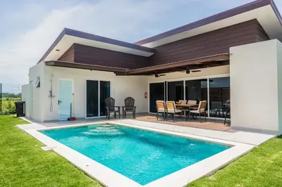 a villa with a swimming pool in front of a house at Entire Property - Triskele Retreat in Esterillos