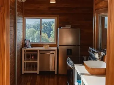 a kitchen with a refrigerator and a sink and a window at luxury wooden house mountain view in Hojancha