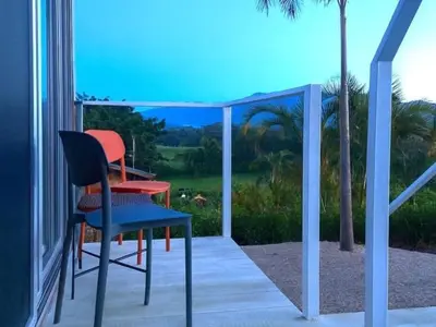 a table and a chair on a porch with a view at luxury wooden house mountain view in Hojancha