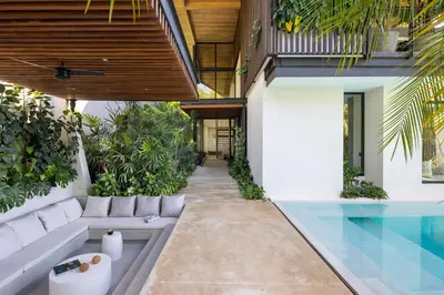 an outdoor living room with a swimming pool and a house at Ohana Villa - Ocean View and a Walk to the Beach in Nosara