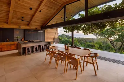 an open kitchen and dining room with a table and chairs at Ohana Villa - Ocean View and a Walk to the Beach in Nosara