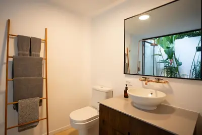 a bathroom with a sink and a toilet and a mirror at Nalu Nosara Pool Villa Sombra in Nosara