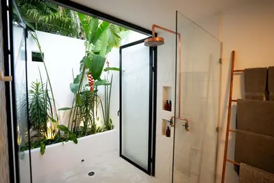 a bathroom with a glass shower with plants at Nalu Nosara Pool Villa Sombra in Nosara