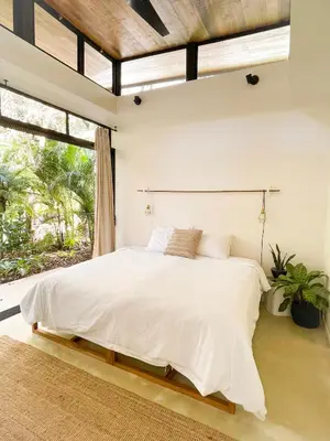 a bedroom with a large white bed with a window at Nalu Nosara Pool Villa Mar in Nosara