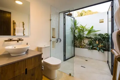 a bathroom with a toilet and a sink and a shower at Nalu Nosara Pool Villa Mar in Nosara