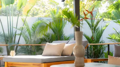 a couch with a vase on a table with plants at New! 5-Min Walk to Surf - Private Pool - 2BR in Playa hermosa