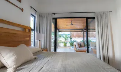a bedroom with a large bed and a living room at New! 5-Min Walk to Surf - Private Pool - 2BR in Playa hermosa
