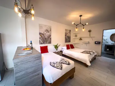 a hotel room with two beds and a desk at Ela Hotel Jaco in Jacó