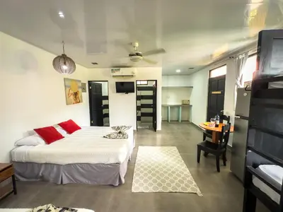 a bedroom with a bed and a table in a room at Ela Hotel Jaco in Jacó