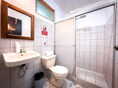 a bathroom with a toilet and a sink and a shower at Ela Hotel Jaco in Jacó