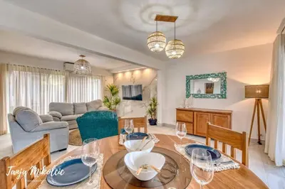 a living room with a table and a couch at Ela Hotel Jaco in Jacó