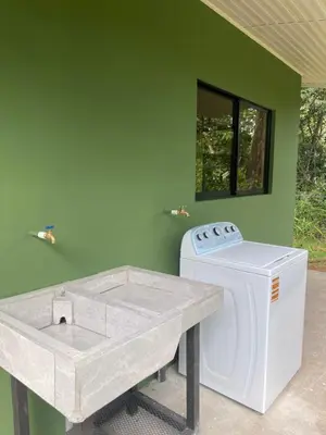 a washing machine sitting next to a green wall at Casa Ema in La Abuela