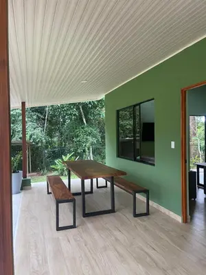 a wooden table and benches in a room with a tv at Casa Ema in La Abuela