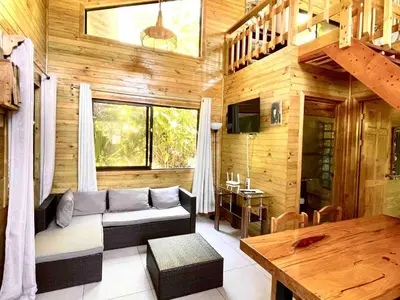 a living room with a couch and a table at Finca Los Mangos in Quepos