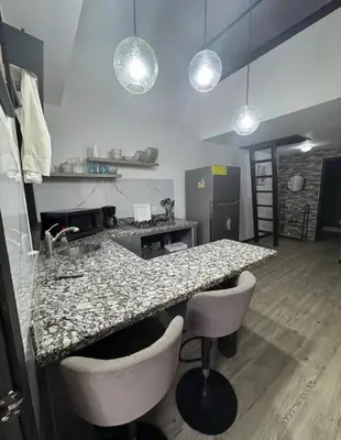 a kitchen with a granite counter top and stools at Casa Bambu in Tapantí