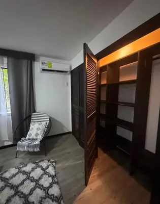a bedroom with a closet and a chair and a rug at Casa Bambu in Tapantí