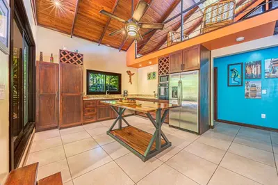 a large kitchen with a table and a ceiling at Casa de los Lorros close to whale tail in Bahia
