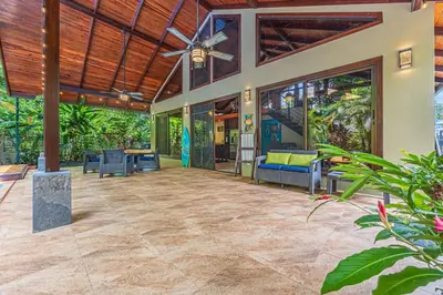 an outdoor patio with a ceiling fan and a table at Casa de los Lorros close to whale tail in Bahia