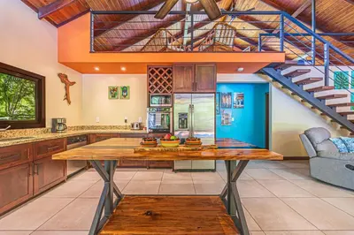 a kitchen with a wooden table and a staircase at Casa de los Lorros close to whale tail in Bahia
